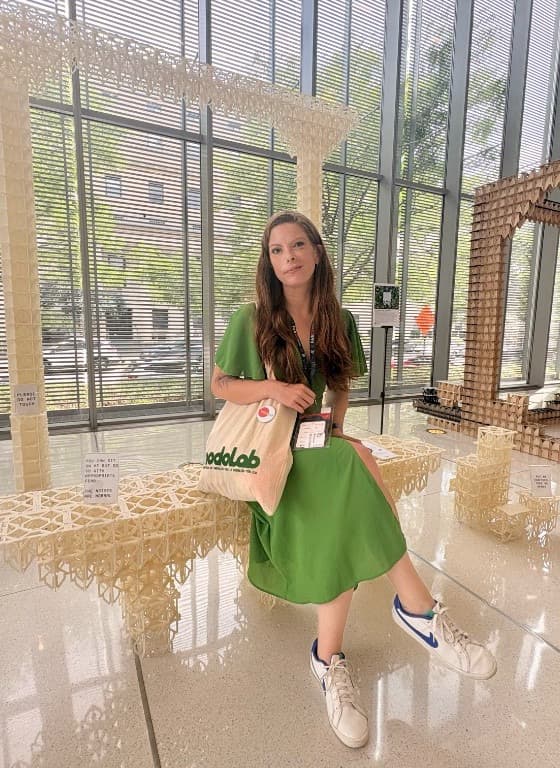 Nicole Fauré sentada en una instalación, con una bolsa de VUCALAB.